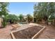 Backyard with mature trees, a pool with rock features, gravel accents, and garden beds for planting at 2229 S 82Nd Ln, Phoenix, AZ 85043