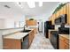 Galley style kitchen with light wood cabinets and modern black appliances at 2229 S 82Nd Ln, Phoenix, AZ 85043