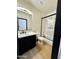 Bathroom with a modern vanity, a framed mirror, and a tub with a glass door at 22504 W Meade Ln, Buckeye, AZ 85326
