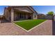Well-manicured backyard features artificial turf, gravel accents, and a covered patio for outdoor living at 22660 N 122Nd Ave, Sun City, AZ 85373