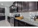 Close up of the kitchen's granite countertops, sleek appliances, and dark cabinets at 22660 N 122Nd Ave, Sun City, AZ 85373