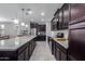 Modern kitchen boasts granite counters, an oversized island, dark cabinets, and stainless steel appliances at 22660 N 122Nd Ave, Sun City, AZ 85373