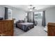 Bright main bedroom showcasing a ceiling fan and large windows for ample natural light at 22660 N 122Nd Ave, Sun City, AZ 85373