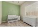 Charming Bedroom featuring a light green accent wall, crib, and dresser at 2716 S Chatsworth --, Mesa, AZ 85209
