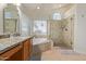 Beautiful bathroom featuring dual sinks, a soaking tub, and a glass-enclosed shower at 3089 E Indigo Bay Dr, Gilbert, AZ 85234