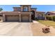 Two-story home with a three-car garage, desert landscaping, and a covered front porch at 3089 E Indigo Bay Dr, Gilbert, AZ 85234