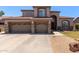 Inviting two-story home with a three-car garage, landscaped front yard, and a welcoming entrance with stone accents at 3089 E Indigo Bay Dr, Gilbert, AZ 85234