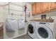 Functional laundry room with wooden cabinets, washer and dryer, and ample storage space at 3089 E Indigo Bay Dr, Gilbert, AZ 85234