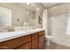 Bright bathroom featuring a double vanity with mosaic backsplash, white countertops, and a shower/tub combo at 31219 N 6Th Pl, Phoenix, AZ 85085