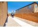 Well-maintained backyard with gravel, paved area, basketball hoop, and secure block fence, perfect for activities at 3511 W Allens Peak Dr, San Tan Valley, AZ 85144
