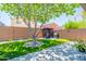 Grassy backyard with a grill under a pergola and block fence, ideal for outdoor entertaining at 3511 W Allens Peak Dr, San Tan Valley, AZ 85144