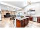 Spacious kitchen with a central island, cherry wood cabinets, stainless steel dishwasher and sink, and an open layout at 3511 W Allens Peak Dr, San Tan Valley, AZ 85144