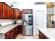 Lovely cherry wood kitchen featuring stainless steel appliances, light countertops, and a modern stainless steel refrigerator at 3511 W Allens Peak Dr, San Tan Valley, AZ 85144