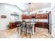 Bright kitchen with granite countertops, cherry wood cabinets, central island with seating, and stainless steel appliances at 3511 W Allens Peak Dr, San Tan Valley, AZ 85144