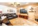 Cozy living room featuring tile floors, a comfortable leather sectional sofa, and a modern entertainment center with mounted TV at 3511 W Allens Peak Dr, San Tan Valley, AZ 85144