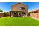 A lush backyard with artificial grass, a covered patio, and exterior view of the home at 37911 N Luke Ln, San Tan Valley, AZ 85140