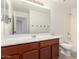 Bathroom featuring a cherry wood vanity, large mirror and full sized bathtub with shower at 37911 N Luke Ln, San Tan Valley, AZ 85140