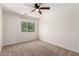 This bedroom has neutral colored walls, carpet, a ceiling fan and a window offering natural light at 37911 N Luke Ln, San Tan Valley, AZ 85140
