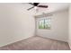 Neutral bedroom with a ceiling fan, plush carpet and a window offering natural light at 37911 N Luke Ln, San Tan Valley, AZ 85140