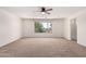 Spacious bedroom with neutral carpet, ceiling fan, and a bright window at 37911 N Luke Ln, San Tan Valley, AZ 85140