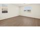 Bedroom with neutral walls and wood-look tile floors and two windows with views to the outside at 3845 N Camden Dr, Florence, AZ 85132