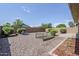 Large gravel backyard with a small garden plot and drought tolerant landscaping at 41279 W Elm Dr, Maricopa, AZ 85138
