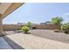 Spacious gravel backyard with mature shrubs and views of neighboring homes at 41279 W Elm Dr, Maricopa, AZ 85138