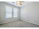 Carpeted bedroom featuring a window and a ceiling fan at 41279 W Elm Dr, Maricopa, AZ 85138