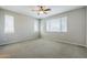 Spacious carpeted bedroom with natural light, ceiling fan, and neutral color palette for a relaxing retreat at 41279 W Elm Dr, Maricopa, AZ 85138