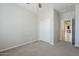Bright carpeted bedroom with closet and hallway entrance at 41279 W Elm Dr, Maricopa, AZ 85138
