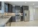Modern kitchen featuring stainless steel appliances, light countertops, and dark cabinetry with plenty of storage at 41279 W Elm Dr, Maricopa, AZ 85138