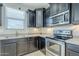 Close up of kitchen with stainless steel appliances, dark cabinetry, light countertops, and tile flooring at 41279 W Elm Dr, Maricopa, AZ 85138