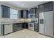 Bright kitchen features stainless steel appliances, dark cabinets, and ample countertop space for cooking at 41279 W Elm Dr, Maricopa, AZ 85138