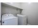 Bright laundry room features a washer, dryer, and shelving for convenient storage at 41279 W Elm Dr, Maricopa, AZ 85138