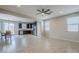 Open-concept living room with dining area, kitchen, tile flooring and ceiling fan at 41279 W Elm Dr, Maricopa, AZ 85138