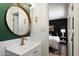 Stylish bathroom with a round mirror, gold faucet, and white vanity, conveniently connected to the main bedroom at 4136 E Eugie Ave, Phoenix, AZ 85032