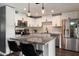 Bright kitchen with stainless steel appliances, white cabinetry, granite countertops, island with seating, and modern pendant lights at 4136 E Eugie Ave, Phoenix, AZ 85032