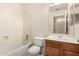 Bright bathroom with a shower-tub combo, toilet, and vanity with a sink and a large mirror at 42458 W Desert Fairways Dr, Maricopa, AZ 85138