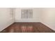 Bright, spacious room with hardwood floors and a window providing natural light at 42458 W Desert Fairways Dr, Maricopa, AZ 85138