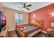Comfortable bedroom with a wooden bed frame, ceiling fan, and a window with natural light at 4408 W Summerside Rd, Laveen, AZ 85339