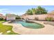 Backyard pool with lush landscaping, rock waterfall feature, and mature trees on a sunny day at 4408 W Summerside Rd, Laveen, AZ 85339