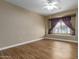 Well-lit bedroom featuring a window seat with purple curtains and sleek wood-look flooring at 4465 E Paradise Village S Pkwy # 1224, Phoenix, AZ 85032