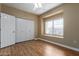 Bright bedroom features wood-look floors, closet, and a sunlit window seat at 4465 E Paradise Village S Pkwy # 1224, Phoenix, AZ 85032