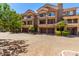 Stylish multi-level townhome with a brick-paved drive, multiple garages, and desert landscaping under a bright blue sky at 4465 E Paradise Village S Pkwy # 1224, Phoenix, AZ 85032
