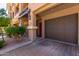 Attached one-car garage and a red front door situated next to a manicured shrub at 4465 E Paradise Village S Pkwy # 1224, Phoenix, AZ 85032