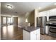 Open-concept living room with stainless steel appliances, island and access to an outdoor balcony at 4465 E Paradise Village S Pkwy # 1224, Phoenix, AZ 85032