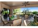 Outdoor patio with ceiling fan overlooking a beautiful pool and green space with a glass table and seating for six at 4548 E Nightingale Ln, Gilbert, AZ 85298