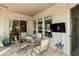Covered outdoor patio perfect for dining with glass top table and seating for six overlooking the community green space at 4548 E Nightingale Ln, Gilbert, AZ 85298