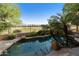 View of the beautiful swimming pool, rock waterfall, and mature landscaping. Adjacent to a well maintained green area at 4548 E Nightingale Ln, Gilbert, AZ 85298