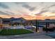 Scenic backyard features a pool, spa, putting green, an outdoor kitchen, and a desert landscape at 460 W Chase St, San Tan Valley, AZ 85143
